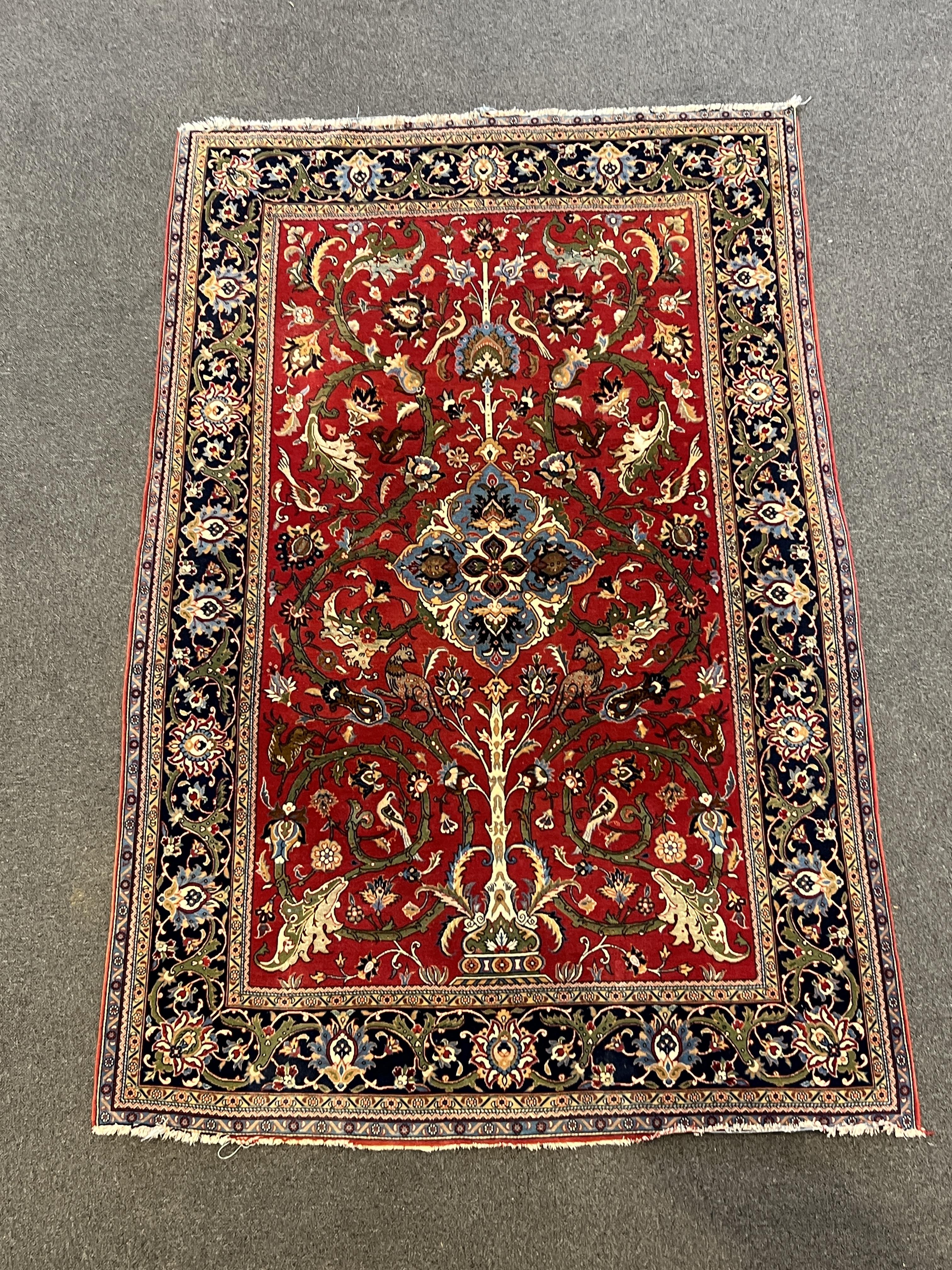 A Kashan red ground rug, woven with scrolling foliage and birds within a dark border, 216 x 138cm. Condition - good